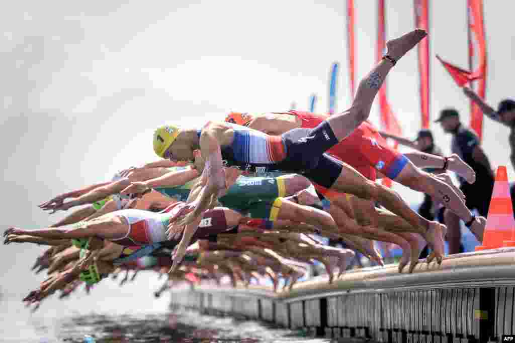 France's Vincent Luis (No1 in Yellow) jumps into Geneva Lake with competitors at the start of the ITU World Triathlon Grand Final in Lausanne, Switzerland, Aug. 31, 2019.