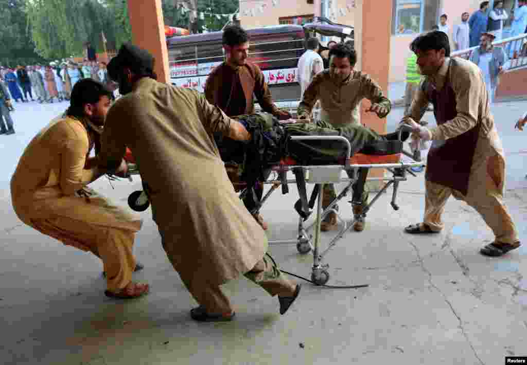 Men carry an injured person to a hospital after a blast in Jalalabad, Afghanistan.