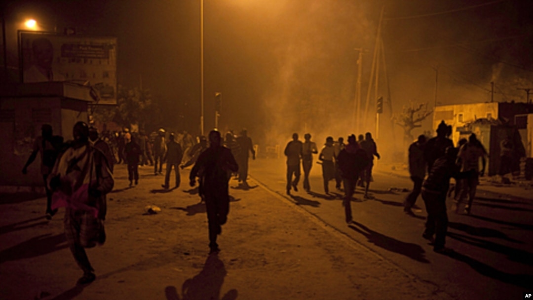 Anti-government protesters run from tear gas in Dakar on January 27, 2012.