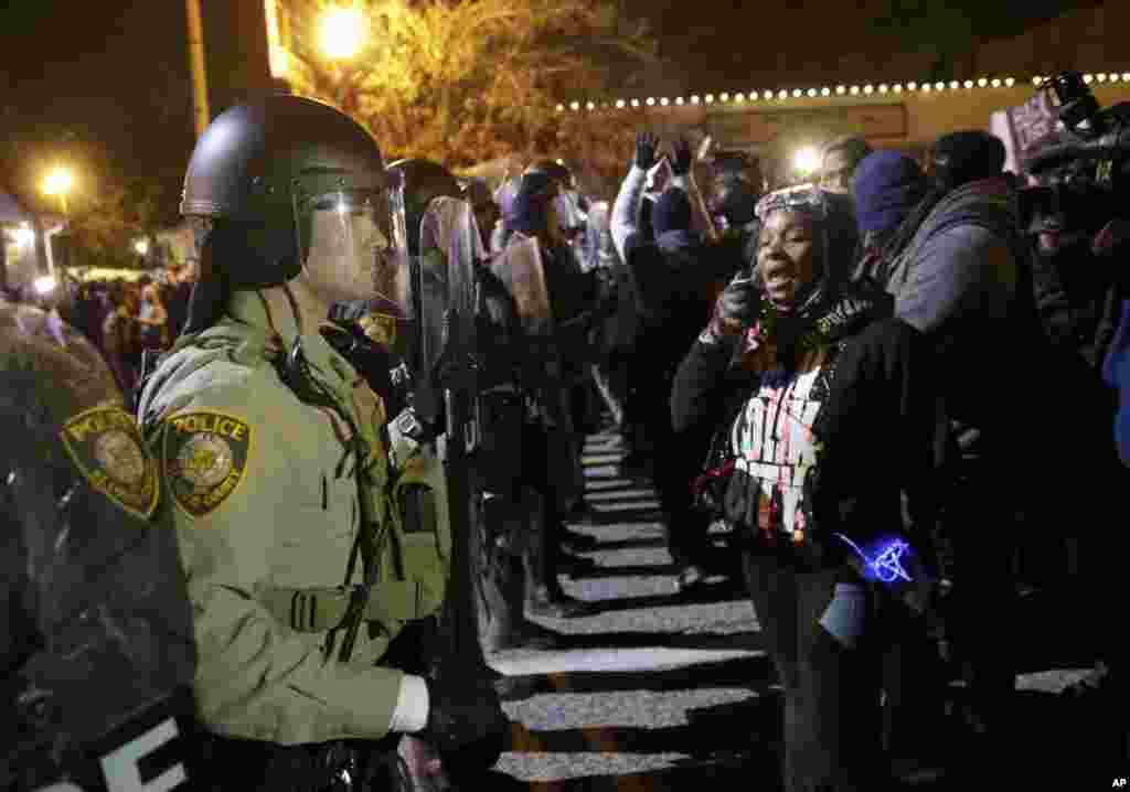 Agentes da polícia de guarda enquanto os manifestantes reagem ao anúncio do Grande Júri de não acusar o agente da polícia Darren Wilson na morte de Michael Brown (18 anos) Nov. 24, 2014, Ferguson, Missouri.