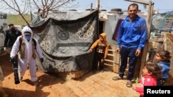 FILE - A municipal worker sanitizes a Syrian refugee camp to combat the spread of coronavirus, in Marjayoun, Lebanon, March 23, 2020.