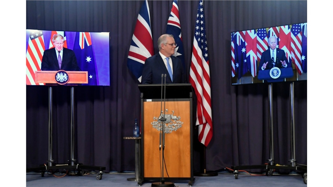 Australia's Prime Minister Scott Morrison, center, appears on stage with video links to Britain's Prime Minister Boris Johnson, left, and U.S. President Joe Biden at a joint press conference at Parliament House in Canberra, Thursday, Sept. 16, 2021.