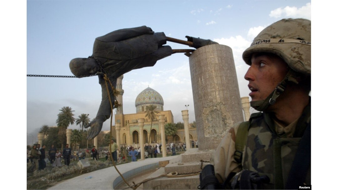FILE - U.S. Marine Corp Assaultman Kirk Dalrymple watches as a statue of Iraq's President Saddam Hussein falls in central Baghdad, April 9, 2003.