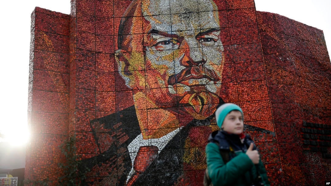 FILE - A boy pauses for photos in front of a mosaic portrait of Vladimir Lenin on Feb. 20, 2014, in Sochi, Russia. (AP Photo/Jae C. Hong)