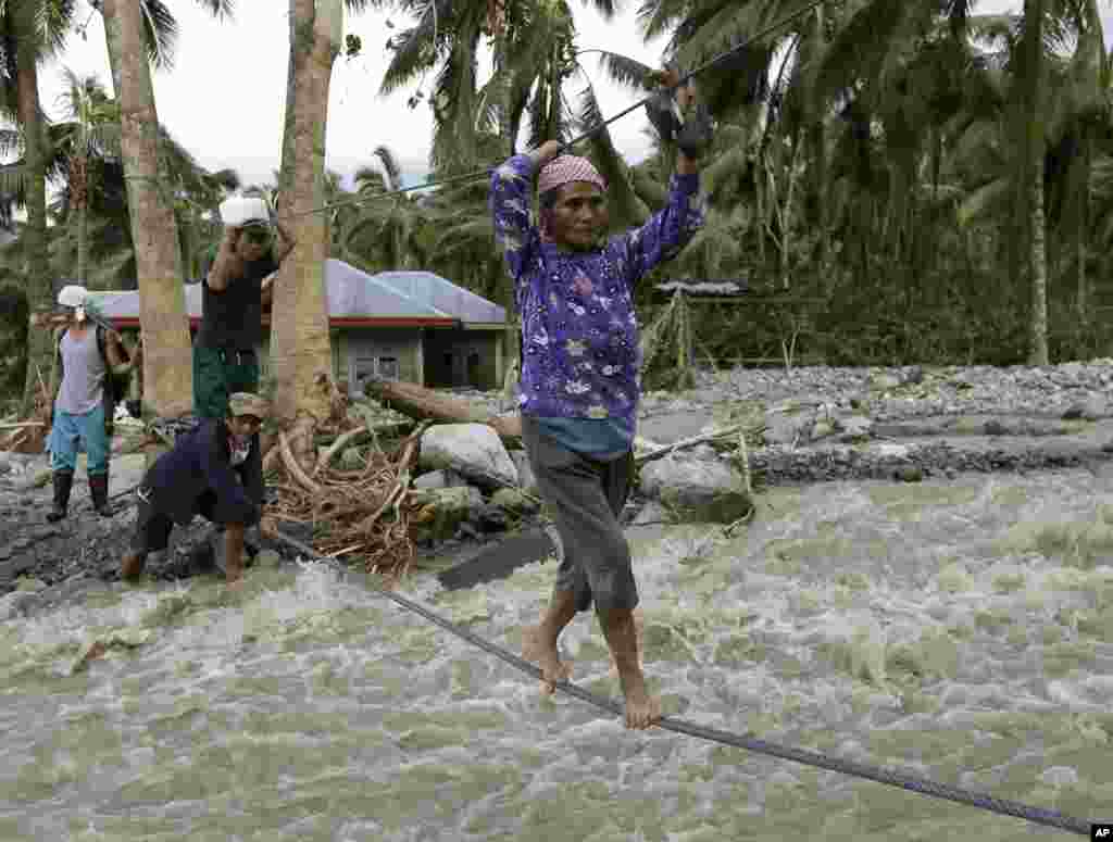 Dân trong làng Andap, tỉnh Compostela Valley dùng các sợi giây để băng ngang một khu vực gặp lũ quét.