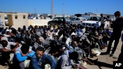 African illegal migrants wait to receive medical help after being rescued by coast guards, in Tripoli, Libya, April 11, 2016. More than 100 migrants were rescued by two coast guard units on Monday after their boat started sinking in the sea. (AP Photo/Mohamed Ben Khalifa) 