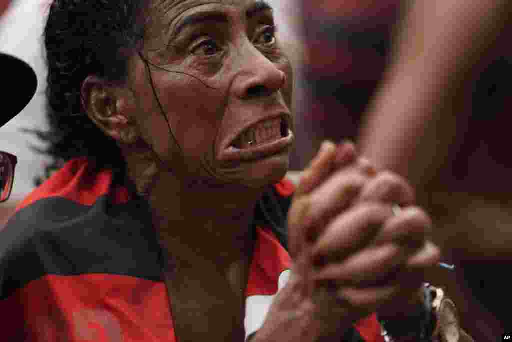 A fan of Brazil's Flamengo soccer team reacts after England's Liverpool scored a goal against the Brazilian team as she watches a live broadcast of the FIFA Club World Cup final soccer match, at the Rocinha slum in Rio de Janeiro, Brazil, Dec. 21, 2019.