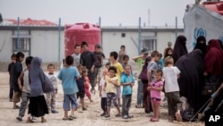 Women and children gather in front their tents at al-Hol camp that houses some 60,000 refugees, including families and supporters of the Islamic State group, many of them foreign nationals, in Hasakeh province, Syria on May 1, 2021.