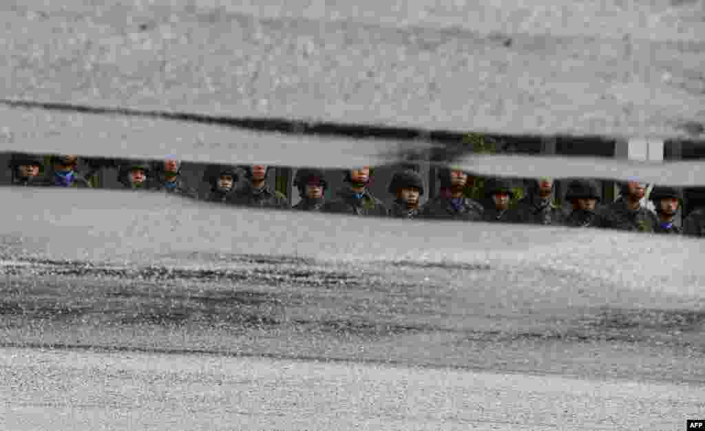 Royal Thai Marines gathered in formation are reflected on a pool of rain water in Chulabhorn Camp in Thailand's southern province of Narathiwat.