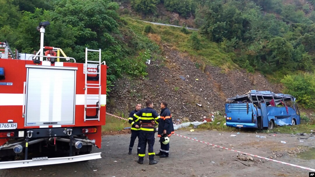 In this handout photo provided by the Bulgarian Interior Ministry, firefighters near the scene where a bus crashed and overturned, near the town of Svoge, Aug. 25, 2018.
