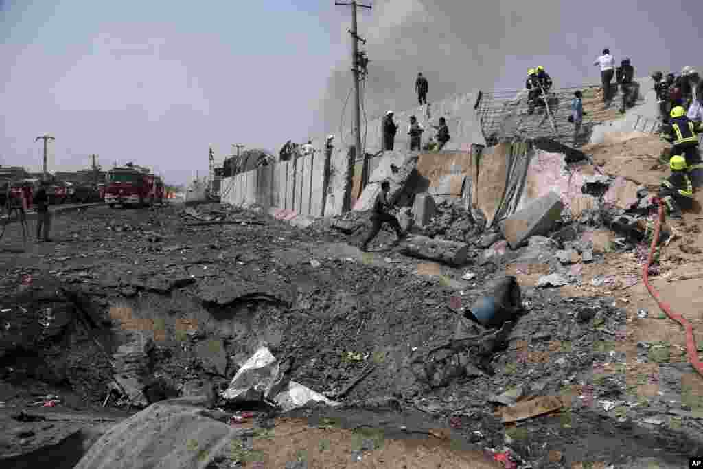 Afghan firefighters work at the site of Monday's suicide bomb attack in Kabul. The attack occurred near the the Green Village, home to several international organizations and guesthouses.