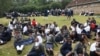 Students sit at the St. George's Girls' Secondary School as they wait to be picked up after learning classes were called off due to the spreading of the COVID-19 coronavirus, in Nairobi on March 17, 2020.