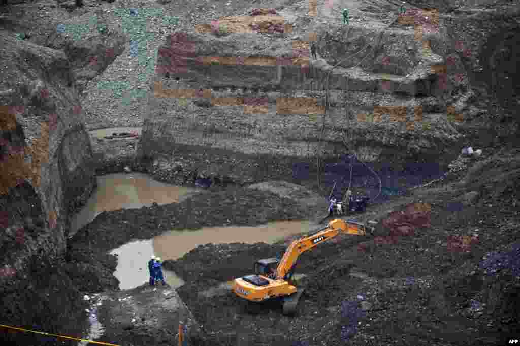 Rescue workers attempt to remove sludge to rescue a group of miners in a gold mine that collapsed in San Antonio, in the rural area of Santander de Quilichao, department of Cauca, Colombia, where independent mine workers were excavating the mine without authorization.