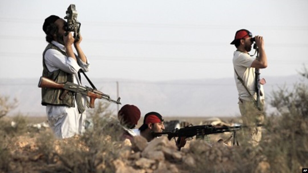 Rebel fighters patrol in the desert south of the Libyan rebel-held town of Chakchuk in the Western Mountains, some 160 km (99.4 miles) southwest of Tripoli, June 4, 2011.