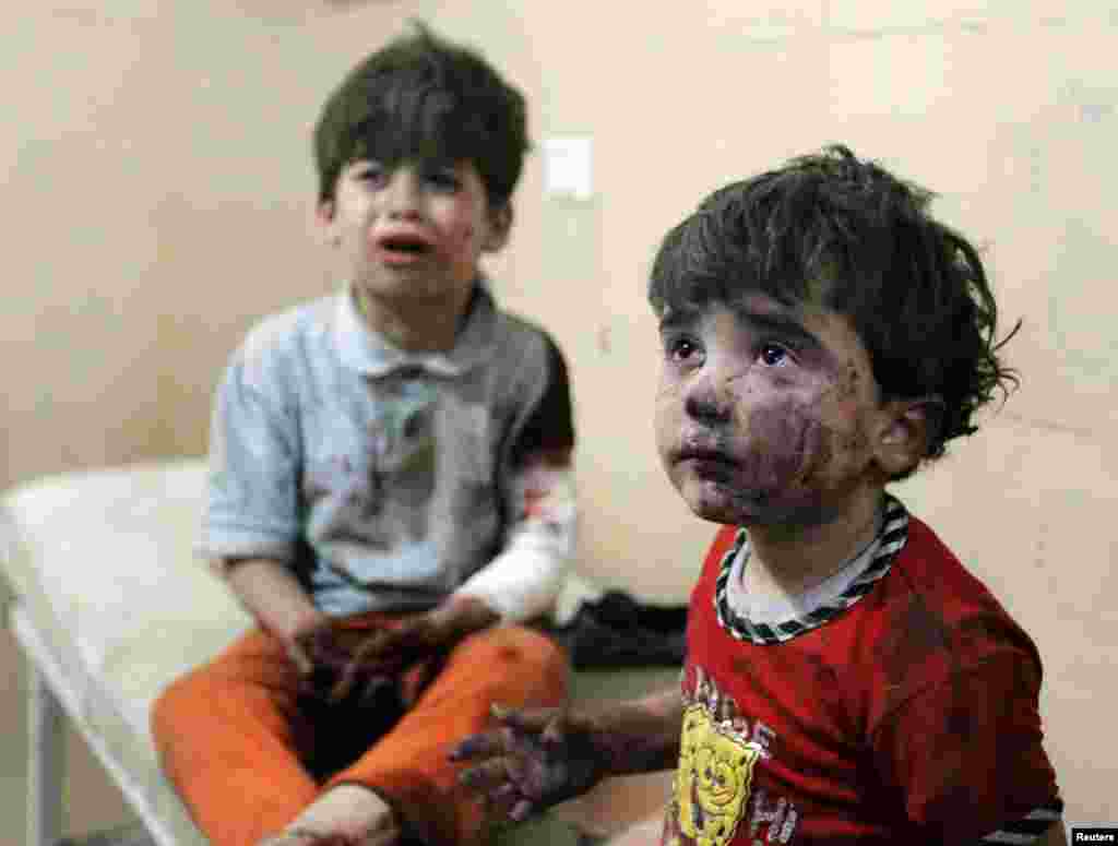 Injured children cry after, according to activists, two barrel bombs were thrown by forces loyal to Syria's president Bashar al-Assad in Hullok neighbourhood of Aleppo, May 1, 2014.