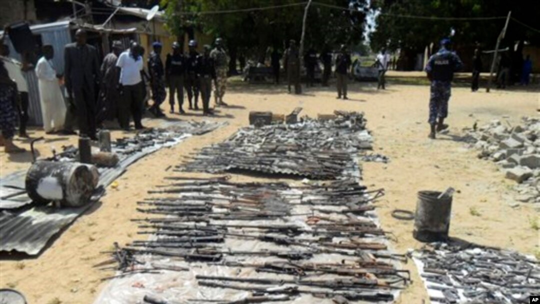 Wani dan sanda yana duba gine gine da ababan hawa da kuma makamai bayan harin da kungiyar Boko Haram ta kai a Damaturu ranar 25 da 25 ga watan Oktoba. An dauki hotunan ranar 28 ga watan Oktoba, 2013.