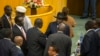 FILE - South Sudan's rebel leader Riek Machar, center-left with back to camera, shakes hands with South Sudan's President Salva Kiir, center-right wearing a black hat, after lengthy peace negotiations in Addis Ababa, Ethiopia, Aug. 17, 2015.