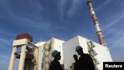 Trabajadores iraníes en frente a la planta nuclear de Bushehr, al sur de Teherán.