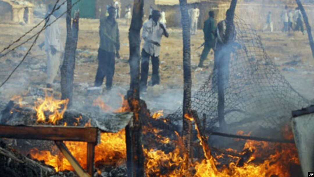 Men look at a market destroyed by a Sudanese air strike in Rubkona, near Bentiu, South Sudan, April 23, 2012.