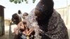 FILE - A health worker tries to immunize a child during a vaccination campaign against polio at Hotoro-Kudu, Nassarawa district of Kano, in northwest Nigeria, April 22, 2017. 