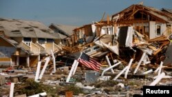 An American flag flies amongst rubble left in the aftermath of Hurricane Michael in Mexico Beach, Florida, Oct. 11, 2018.