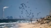 Un avión deja caer ayuda humanitaria sobre el norte de la Franja de Gaza. Foto captada desde el centro de Gaza, el lunes 25 de marzo de 2024. 