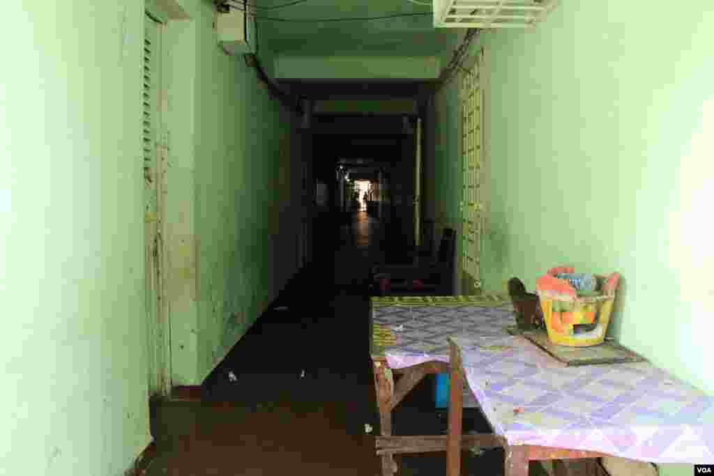 Residents store tables and cook stoves inside this White Building hallway. They use these cook stoves to prepare food for their mobile food stores, in Phnom Penh, Cambodia, Sept. 5, 2014. (Nov Povleakhena/VOA)