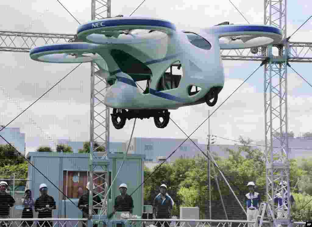 NEC Corp.'s machine with propellers hovers at the company's facility in Abiko near Tokyo, Japan. The Japanese electronics maker showed a "flying car," a large drone-like machine with four propellers that hovered steadily for about a minute.