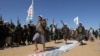Tribesmen loyal to Houthis march on U.S. and Israeli flags during a military parade for new recruits amid escalating tensions with the U.S.-led coalition in the Red Sea, in Bani Hushaish, Jan. 22, 2024. (Khaled Abdullah/Reuters)