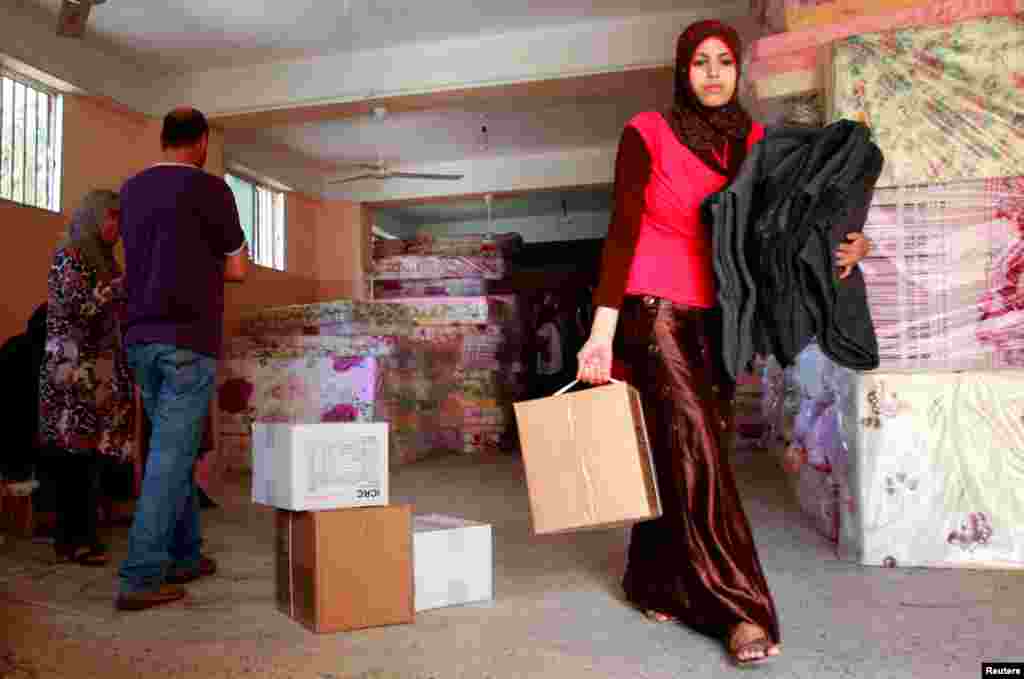 A refugee receives blankets and aid from the International Committee of the Red Cross (ICRC) at Baddawi camp in northern Lebanon, Oct. 4, 2012.