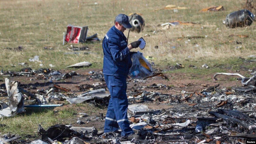 An Emergencies Ministry member searches for belongings at the site where the downed Malaysia Airlines flight MH17 crashed, near the village of Hrabove (Grabovo) in Donetsk region, eastern Ukraine, October 13, 2014.