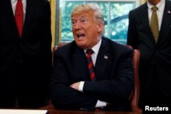 FILE - U.S. President Donald Trump talks to reporters about the killing of Saudi journalist Jamal Khashoggi, following a bill signing ceremony at the White House in Washington, Oct. 23, 2018.