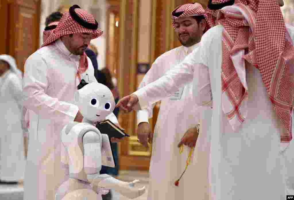 Delegates chat near a robot during the Future Investment Initiative forum at the King Abdulaziz Conference Centre in Saudi Arabia's capital Riyadh.