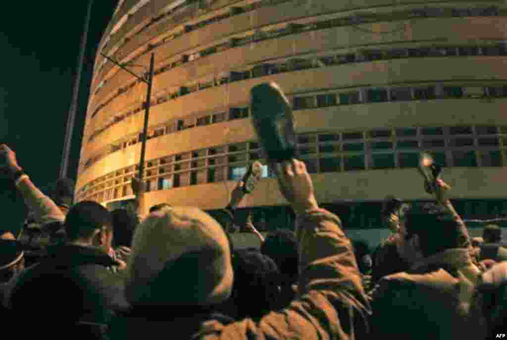 Anti-government protesters hold shoes in the air as a sign of contempt as they surround the state television building following Egyptian President Hosni Mubarak's televised speech, on the Corniche in downtown Cairo, Egypt Thursday, Feb. 10, 2011. Mubarak