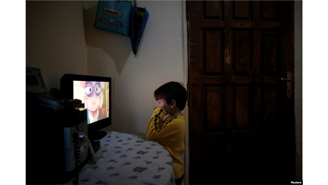 Panagiotis Argyros watches cartoons in his house at the suburb of Keratsini in Athens, Greece, March 28, 2017.