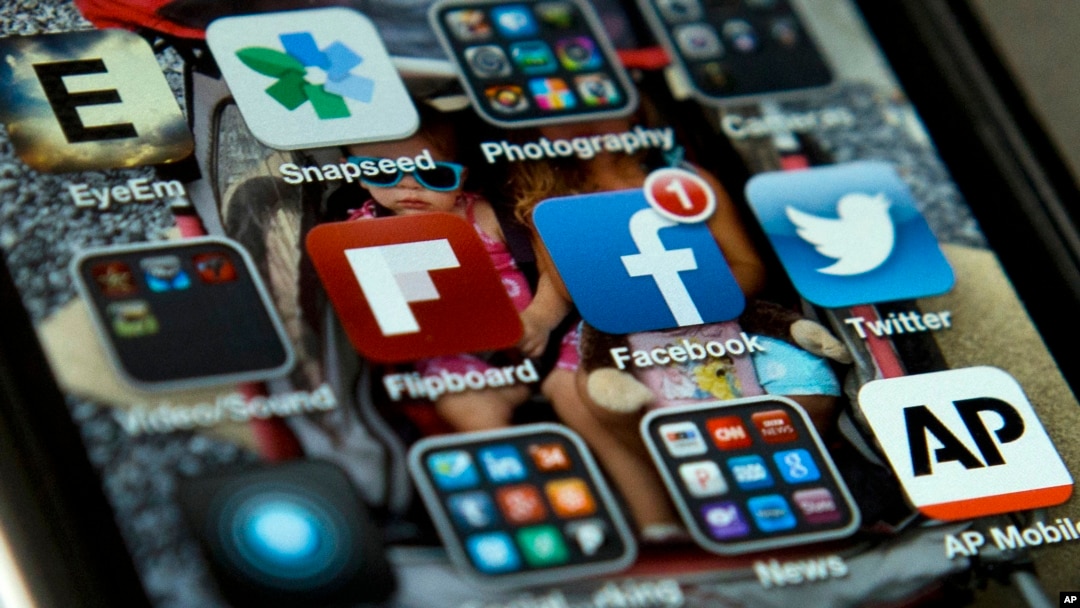 FILE - An iPhone with Twitter, Facebook and other apps, May 21, 2013. U.S. internet companies are taking a harder look at their policies that have promoted free expression around the world.