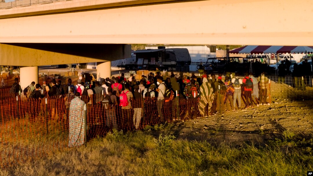 Migrantes, muchos procedentes de Haití, hacen fila el viernes 24 de septiembre de 2021 para subir a autobuses debajo del Puente Internacional de Del Rio, en Del Rio, Texas. 