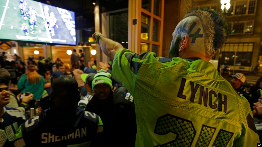 Stunned Seattle Seahawks fan Dustin Pittis points at a TV monitor, Feb. 1, 2015, as he watches the end of Super Bowl XLIX at a bar in Seattle, Washington.