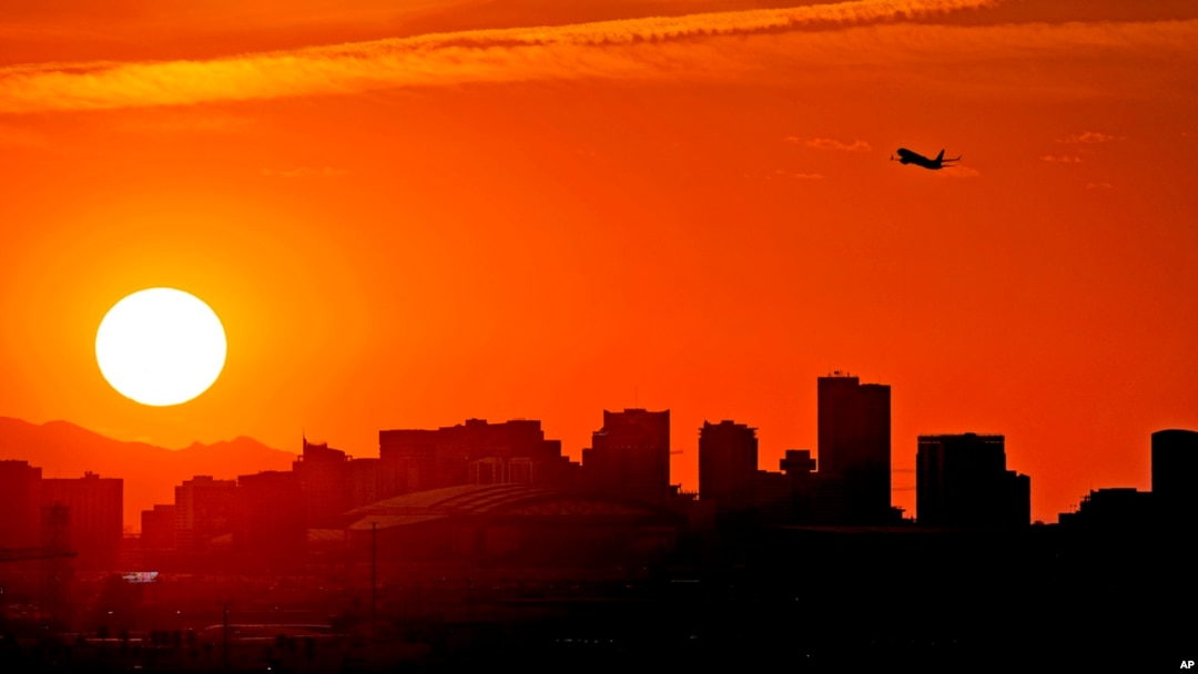 FILE - A jet takes flight from Sky Harbor International Airport as the sun sets over Phoenix, July 12, 2023.