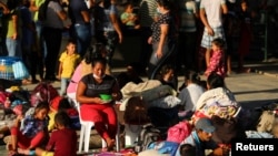 Migrantes venezolanos en Arauquita, Colombia, entre ellos mujeres y menores de edad, acampan en una estación temporal tras enfrentamientos militares en Venezuela en el mes de abril de 2021.