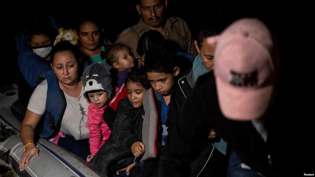 ARCHIVO - Familias migrantes solicitantes de asilo viajan en una balsa inflable mientras cruzan el río Grande hacia los Estados Unidos desde México en Roma, Texas, EE. UU., 8 de junio de 2021.
