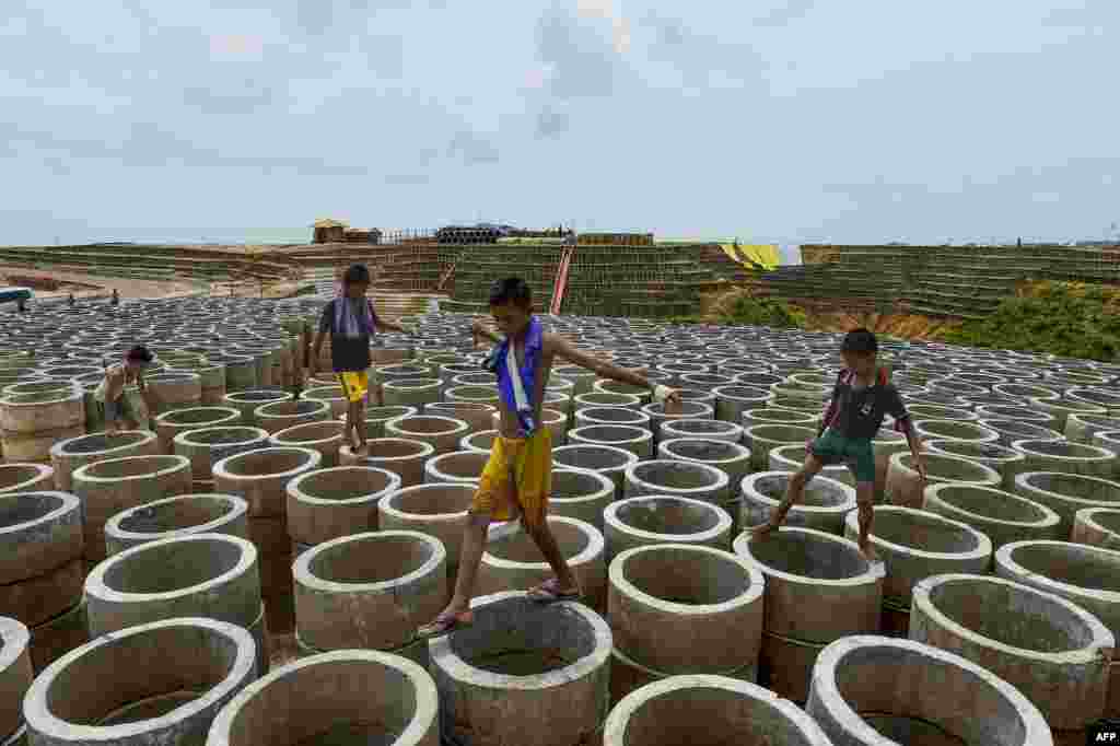Rohingya children walk on sewage pipes at the Kutupalong refugee camp in Ukhia.
