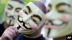 FILE - Activists of the international network "Anonymous" behind their masks posing in Berlin. 