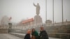 Ethnic Uighurs sit near a statue of China's late Chairman Mao Zedong in Kashgar, Xinjiang Uighur Autonomous Region, China, March 23, 2017. 