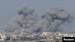 Edificios destruidos envueltos en densas humaredas se observan en la Franja de Gaza desde el sur de Israel el 6 de diciembre de 2023.