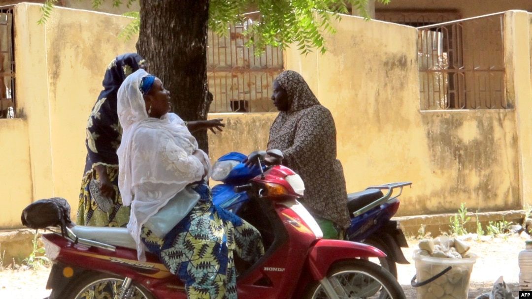 FILE - Women chatting while sitting on their bikes in a district of Maroua, northern Cameroon.