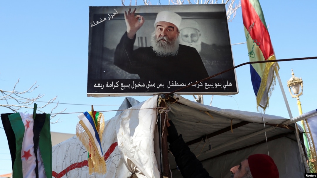 FILE - A sign depicting Syrian Druze leader Sheikh Hikmat al-Hajri is seen in Suwayda, Syria, Feb. 25, 2025.