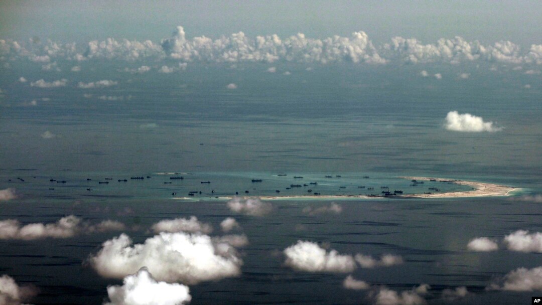 FILE - This aerial photo taken through a glass window of a military plane shows China's alleged on-going reclamation of Mischief Reef in the Spratly Islands in the South China Sea, May 11, 2015.