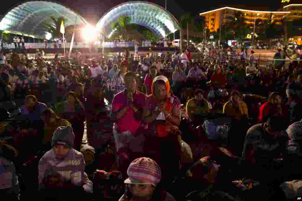 A.G. Praxida (center left) and Mary Josephine Warnakulasuriya pray with others as they wait to attend a mass by Pope Francis, at the Galle Face in Colombo, Sri Lanka, Jan. 13, 2015.
