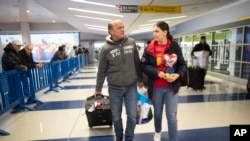 Mohammed Hafar, a la izquierda, ayuda a su hija Jana a llevar su equipaje mientras salen del aeropuerto JFK de Nueva York, el 3 de diciembre de 2019 (Foto: AP) 